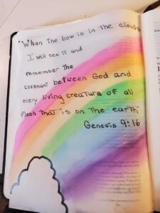 image of an open bible with rainbow and handwritten passage