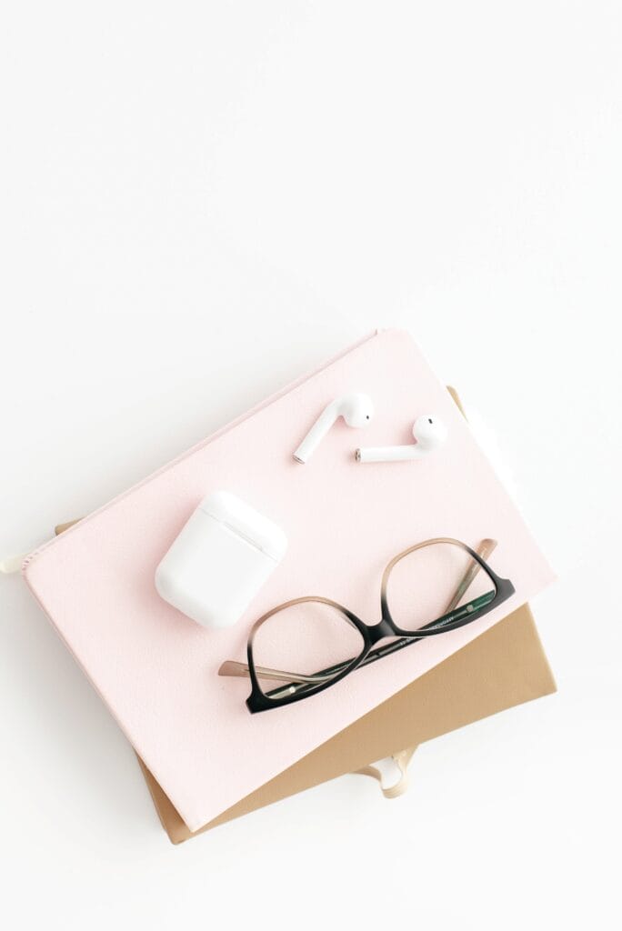 a journal, glasses and air pods