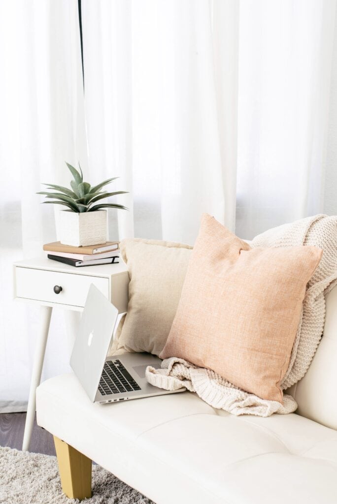 a laptop and pillow on a couch
