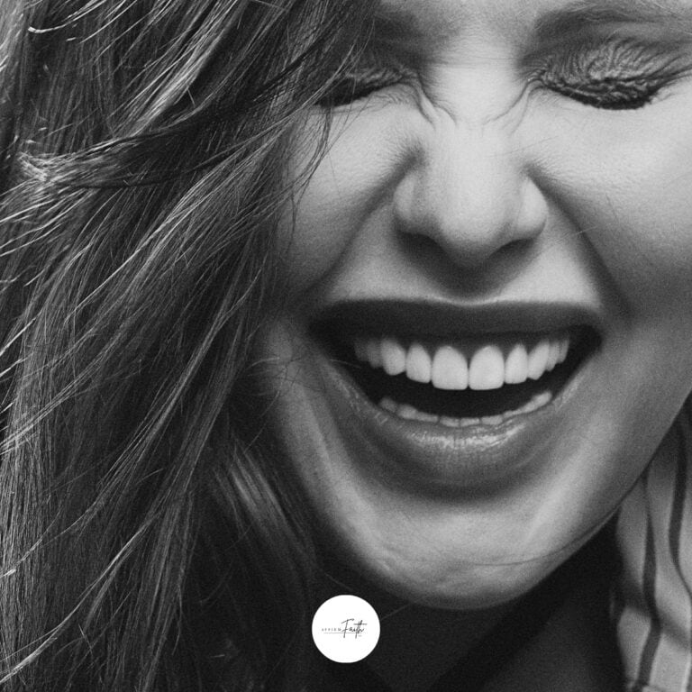 a black and white image of a woman laughing