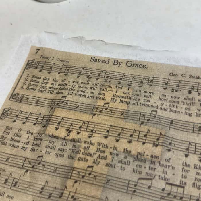 one ply tissue paper with saved by grace lyrics laid over mod podge prepared wood cross 