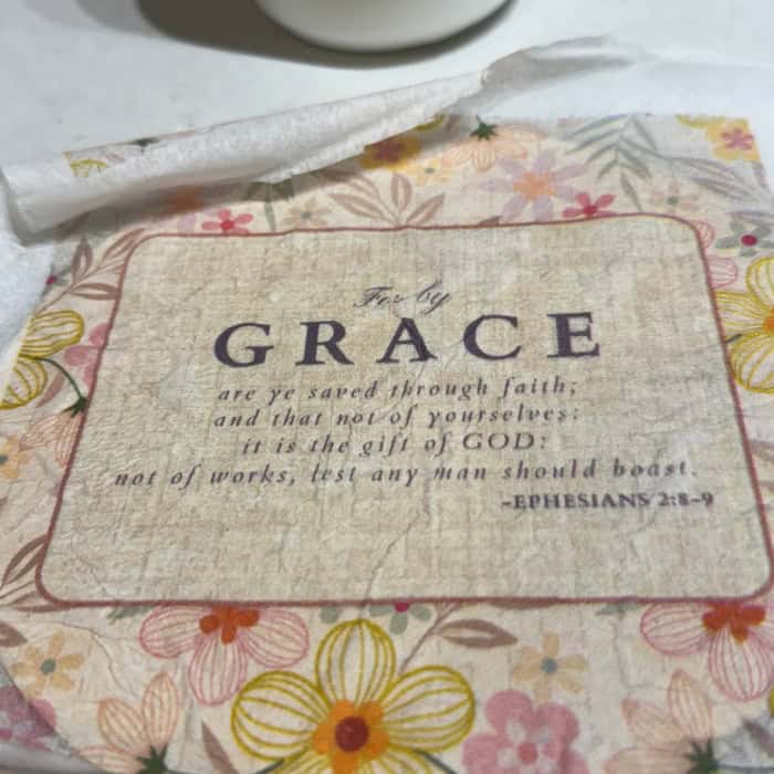 Grace napkin laid on top of mod podge prepped wood circle for easy decoupage craft projects